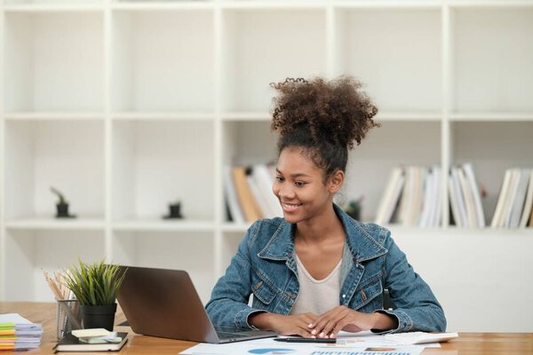 Smart African women working in beautiful office, working on Laptop, use the phone, talking on the cellphone. . High quality photo