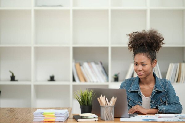 Smart African women working in beautiful office, working on Laptop, use the phone, talking on the cellphone. . High quality photo