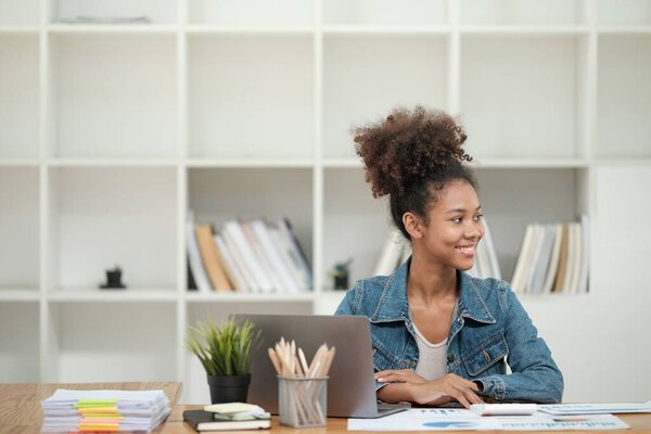 Smart African women working in beautiful office, working on Laptop, use the phone, talking on the cellphone. . High quality photo