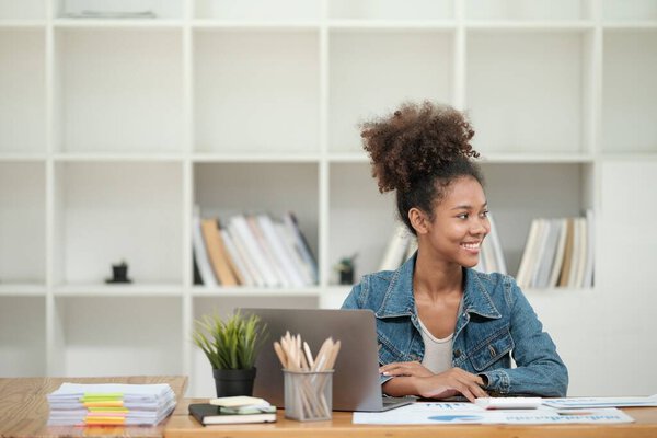 Smart African women working in beautiful office, working on Laptop, use the phone, talking on the cellphone. . High quality photo