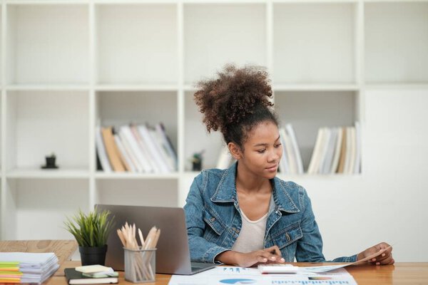 Smart African women working in beautiful office, working on Laptop, use the phone, talking on the cellphone. . High quality photo