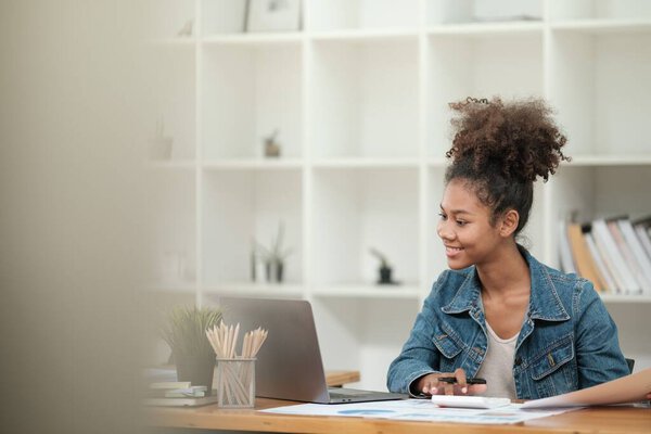 Smart African women working in beautiful office, working on Laptop, use the phone, talking on the cellphone. . High quality photo