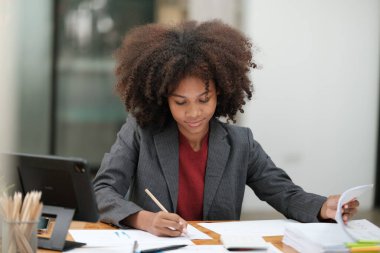 Ofiste bilgisayar telefonu ve tabletle çalışan Amerikalı Afrikalı Kadın. Yüksek kalite fotoğraf