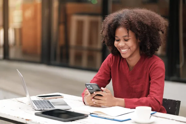 Bilgisayarlı telefon ve tabletle çalışan Amerikalı Afrikalı Kadın. Yüksek kalite fotoğraf