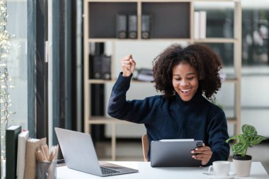 Ofiste bilgisayar telefonu ve tabletle çalışan Amerikalı Afrikalı Kadın. Yüksek kalite fotoğraf