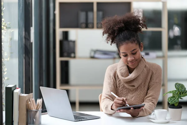 American African Woman working in the office with computer phone and Tablet. High quality photo