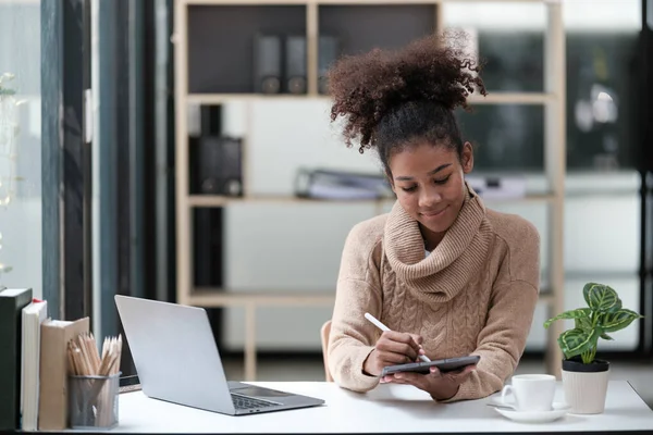 American African Woman working in the office with computer phone and Tablet. High quality photo