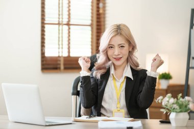 Ofiste dizüstü bilgisayarı kapat, Asyalı mutlu iş kadını resmi takım elbiseli iş yerinde çalışıyor. Çekici bayan ofis çalışanı gülümsemesi. Yüksek kalite fotoğraf