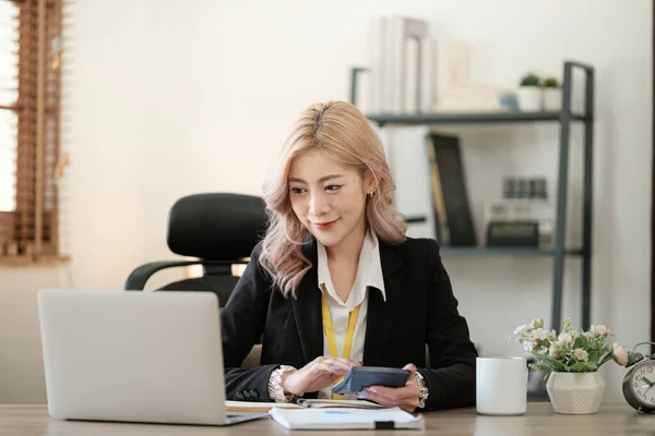 Close up on laptop in office, Asian happy beautiful businesswoman in formal suit work in workplace. Attractive female employee office worker smile. High quality photo