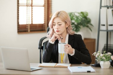 Ofiste dizüstü bilgisayarı kapat, Asyalı mutlu iş kadını resmi takım elbiseli iş yerinde çalışıyor. Çekici bayan ofis çalışanı gülümsemesi. Yüksek kalite fotoğraf