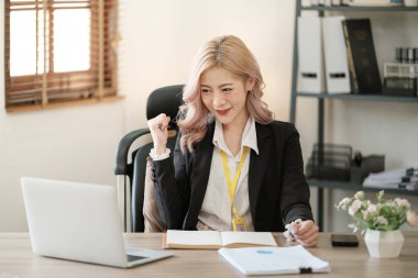 Ofiste dizüstü bilgisayarı kapat, Asyalı mutlu iş kadını resmi takım elbiseli iş yerinde çalışıyor. Çekici bayan ofis çalışanı gülümsemesi. Yüksek kalite fotoğraf