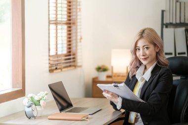 Ofiste dizüstü bilgisayarı kapat, Asyalı mutlu iş kadını resmi takım elbiseli iş yerinde çalışıyor. Çekici bayan ofis çalışanı gülümsemesi. Yüksek kalite fotoğraf