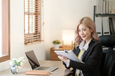 Ofiste dizüstü bilgisayarı kapat, Asyalı mutlu iş kadını resmi takım elbiseli iş yerinde çalışıyor. Çekici bayan ofis çalışanı gülümsemesi. Yüksek kalite fotoğraf