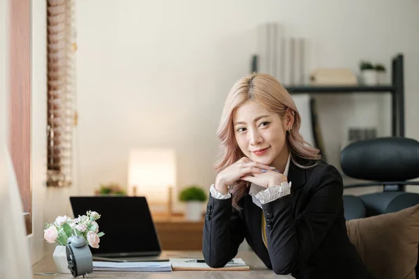 Close up on laptop in office, Asian happy beautiful businesswoman in formal suit work in workplace. Attractive female employee office worker smile. High quality photo