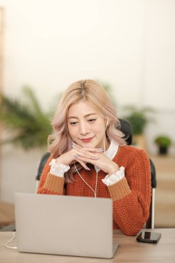 Akıllı telefon bilgisayarı ya da tablet kullanan Asyalı genç bir kadının portresi ev ofisinde çalışıyor, serbest iş dünyası online konsepti. Merhaba Kaliteli Fotoğraf