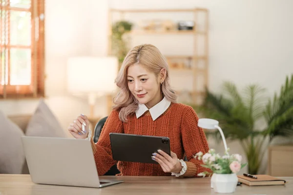 stock image Portrait of Asian young woman working using smartphone computer or tablet working online at home office , freelance business online concept. Hi Quality Photo