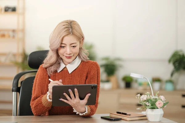 stock image Portrait of Asian young woman working using smartphone computer or tablet working online at home office , freelance business online concept. Hi Quality Photo