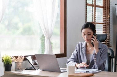 Stüdyosunda dizüstü bilgisayarla çalışan yaratıcı Asyalı genç bir kadın. Yüksek kalite fotoğraf