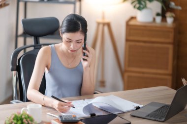 Güzel Asyalı genç kadın sosyal medyayla günlük işler yapıyor. Serbest çalışan kadın online satış pazarlaması yapıyor. İnternetten alışveriş. Merhaba kaliteli fotoğraf..