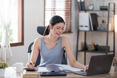 Güzel Asyalı genç kadın sosyal medyayla günlük işler yapıyor. Serbest çalışan kadın online satış pazarlaması yapıyor. İnternetten alışveriş. Merhaba kaliteli fotoğraf..