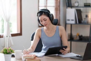 Güzel Asyalı genç kadın sosyal medyayla günlük işler yapıyor. Serbest çalışan kadın online satış pazarlaması yapıyor. İnternetten alışveriş. Merhaba kaliteli fotoğraf..