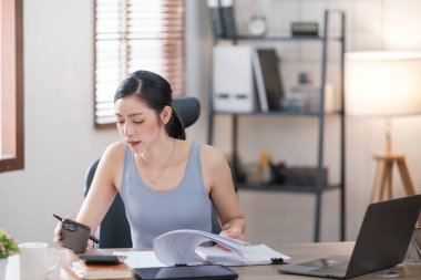 Güzel Asyalı genç kadın sosyal medyayla günlük işler yapıyor. Serbest çalışan kadın online satış pazarlaması yapıyor. İnternetten alışveriş. Merhaba kaliteli fotoğraf..