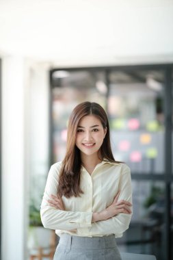 Ofisteki kameraya gülümseyen çekici Asyalı kadın. Yüksek kalite fotoğraf.