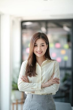 Ofisteki kameraya gülümseyen çekici Asyalı kadın. Yüksek kalite fotoğraf.