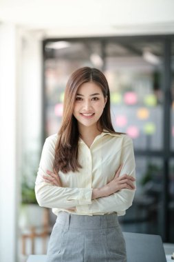 Ofisteki kameraya gülümseyen çekici Asyalı kadın. Yüksek kalite fotoğraf.