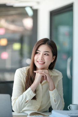 Ofisin penceresinden bakan gülümseyen çekici Asyalı kadın. Yüksek kalite fotoğraf.