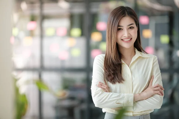 Ofisteki kameraya gülümseyen çekici Asyalı kadın. Yüksek kalite fotoğraf.