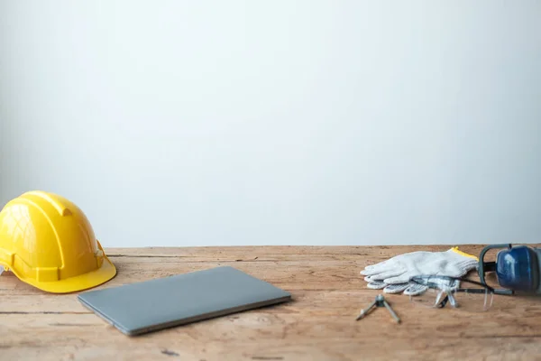 Construction concepts. White safety helmets blueprints on the engineering desks. Hard safety wear helmet hat on desks at construction site. High quality photo