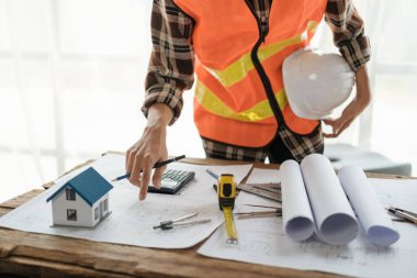 Bir ev inşa etmek için planda çalışan inşaat mühendisi. Yüksek kalite fotoğraf