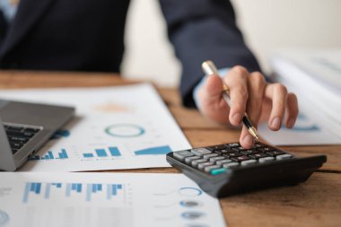 Hesap makineli genç adamı kapat evde notlar alırken, el deftere yazıyor. Tasarruf kavramı. Yüksek kalite fotoğraf