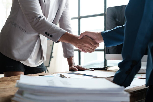 Handshake as successful negotiation ending, close-up. Unknown business people shaking hands after contract signing in modern office. High quality photo