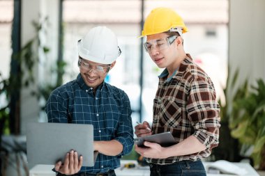 İki mühendis projeyi tartışıyor ve planlıyor. Mühendislerin beyin fırtınası. İnşaat mühendisliği kavramsal. Ofiste üç mimar var ve projeyi tartışıyorlar. Yüksek kalite fotoğraf