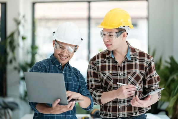 İki mühendis projeyi tartışıyor ve planlıyor. Mühendislerin beyin fırtınası. İnşaat mühendisliği kavramsal. Ofiste üç mimar var ve projeyi tartışıyorlar. Yüksek kalite fotoğraf