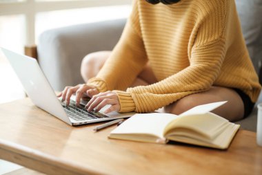 Güzel Asyalı kadın internette dizüstü bilgisayarla oturma odasında öğreniyor. Yüksek kalite fotoğraf