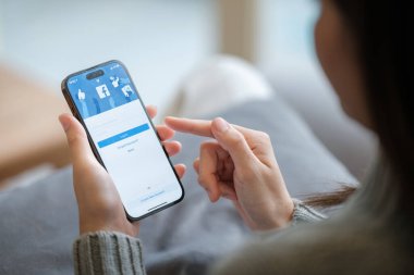 CHIANG MAI, Tayland - Nisan. 19.2023: Ekranda Facebook uygulaması olan iPhone 14 Pro Max 'i tutan kadın. Instagram popüler bir online sosyal ağ hizmetidir. Yüksek kalite fotoğraf