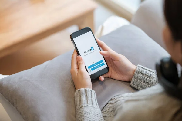 CHIANG MAI, Tayland - Nisan. 19.2023: Ekranda LinkedIn uygulaması olan iPhone 14 Pro Max 'i tutan kadın. Instagram popüler bir online sosyal ağ hizmetidir. Yüksek kalite fotoğraf