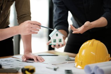 Mühendisler danışmanlık ekibi, ofis için bina modelleri yapan müşterileri için tasarım planları hazırlamaya yakın. Yüksek kalite fotoğraf