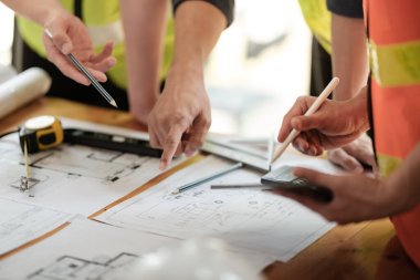 Grup mühendislerini kapatın. Proje hakkında tartışın ve plan yapın. Mühendislerin beyin fırtınası. İnşaat mühendisliği kavramsal. Ofiste üç mimar var ve projeyi tartışıyorlar. Yüksek kalite fotoğraf