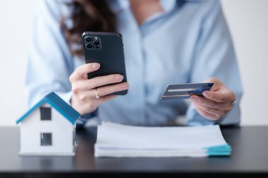 Akıllı telefonu ve kredi kartı olan Asyalı bir kadın, mal ve hizmetleri ödemek için kredi kartı bilgilerini, akıllı telefon ile online alışveriş konseptini ödemek için dolduruyor. Yüksek kalite fotoğraf