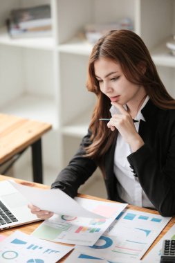 Asyalı İş kadını, bir ofis masası, vergi, rapor, muhasebe, istatistik ve analitik araştırma konseptinde matematik finansmanı için hesap makinesi ve dizüstü bilgisayar kullanıyor. Yüksek kalite fotoğraf