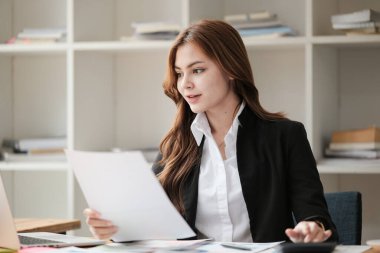 Asyalı İş kadını, bir ofis masası, vergi, rapor, muhasebe, istatistik ve analitik araştırma konseptinde matematik finansmanı için hesap makinesi ve dizüstü bilgisayar kullanıyor. Yüksek kalite fotoğraf