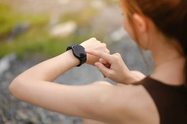 stock image Burning calories. Cropped closeup of a fit woman looking at her smart watch counting burned calories during her workout at the gym. Woman using fitness bracelet copyspace. High quality photo