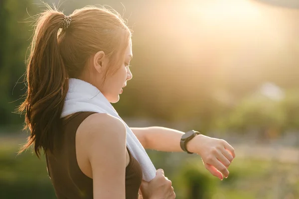 stock image Healthy woman relax after cool down and looking smart watch for check timing run. Woman workout after fitness and jogging session at the park. Healthy and Lifestyle Concept. High quality photo