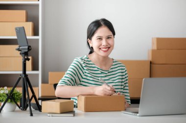 Küçük işletme girişimcisi ya da serbest çalışan bir Asyalı kadının bilgisayarı kutusu, genç başarılı Asyalı kadının el kaldırışı, online pazarlama kutusu ve teslimatı, KME konsepti. Yüksek