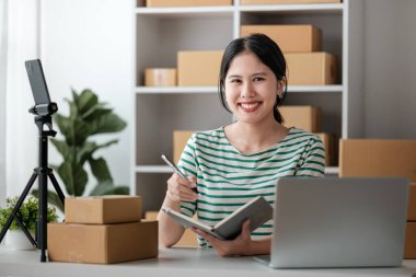 Küçük işletme girişimcisi ya da serbest çalışan bir Asyalı kadının bilgisayarı kutusu, genç başarılı Asyalı kadının el kaldırışı, online pazarlama kutusu ve teslimatı, KME konsepti. Yüksek