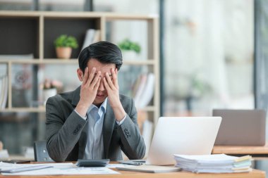 Modern Ofiste Dizüstü bilgisayar kullanan Genç Stresli İş Adamı. Yönetici, Finansal Fikirlerin Başarılı Olmasını Düşünüyor. Mutlu Adam Şirket için Problem Çözme Çözümleri Bulma konusunda gülümsüyor. Yüksek